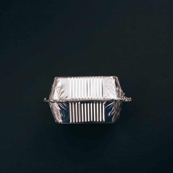 Stop plastic pollution. Aluminum foil silver container for food on dark background, top view. No to single-use plastic. An evironmental problem, EU directive